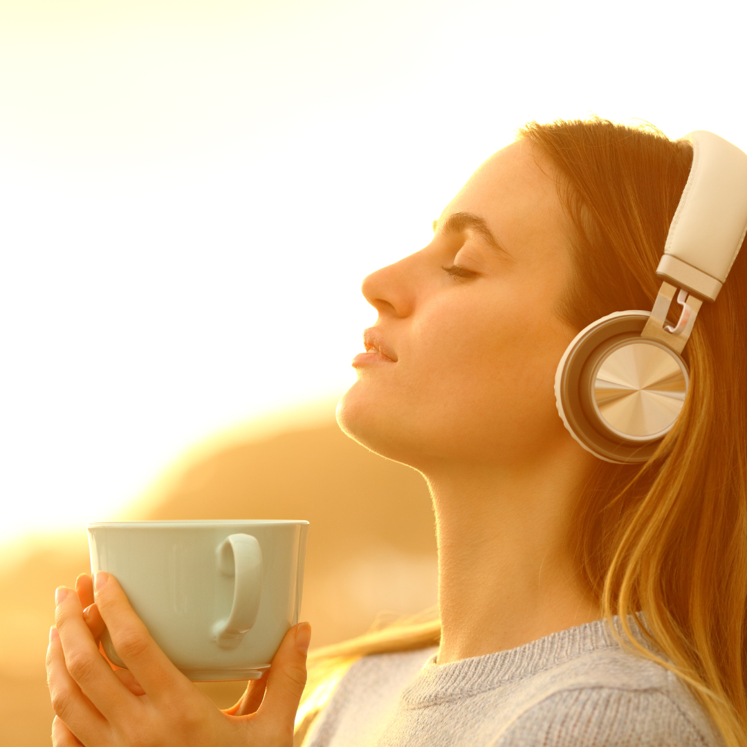 Mujer disfrutando de un momento de relajación mientras escucha música, ilustrando la relación entre el bienestar emocional y la salud de la piel.